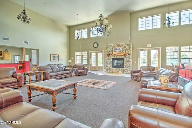 carpeted living room with a notable chandelier, a fireplace, and french doors