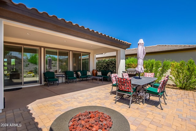 view of patio with an outdoor living space with a fire pit and area for grilling