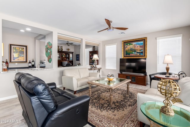 living room featuring light wood-type flooring, a wealth of natural light, and ceiling fan