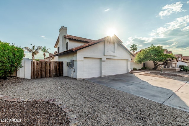 6133 E Saddleback St, Mesa, AZ 85215 - view of property exterior with concrete driveway, stucco siding, a tiled roof, an attached garage, and a chimney