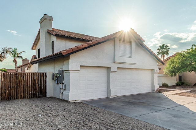 6133 E Saddleback St, Mesa, AZ 85215 - view of property exterior featuring driveway, a chimney, a tiled roof, an attached garage, and stucco siding