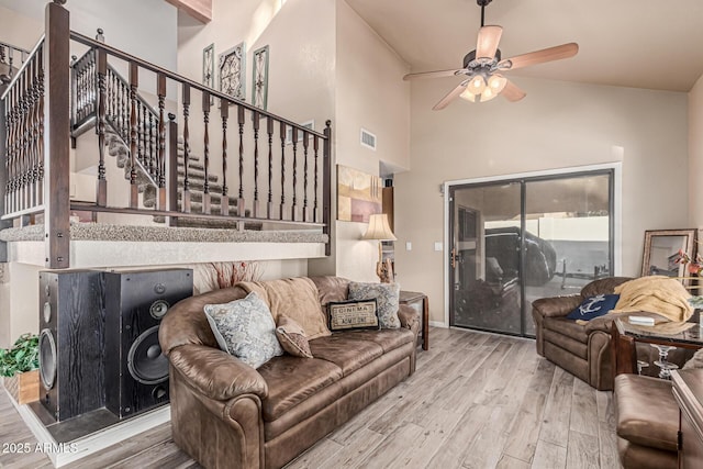 6133 E Saddleback St, Mesa, AZ 85215 - living area featuring ceiling fan, wood finished floors, stairway, and a towering ceiling