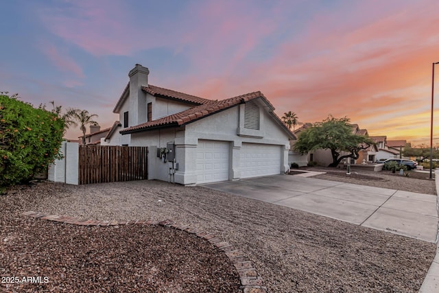 6133 E Saddleback St, Mesa, AZ 85215 - view of home's exterior with a chimney, stucco siding, a garage, driveway, and a tile roof