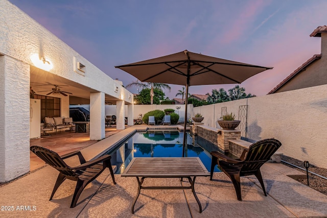 6133 E Saddleback St, Mesa, AZ 85215 - pool at dusk with a fenced backyard, a patio, and a ceiling fan
