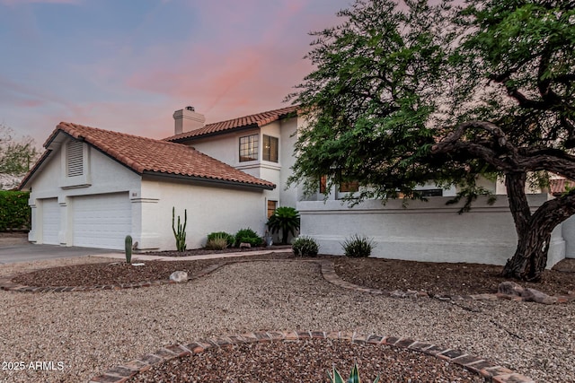 6133 E Saddleback St, Mesa, AZ 85215 - view of property exterior featuring a chimney, stucco siding, a tiled roof, concrete driveway, and a garage