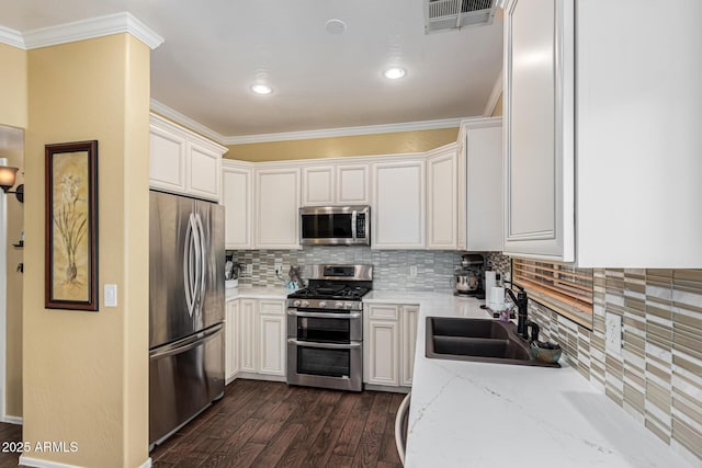 kitchen featuring sink, stainless steel appliances, light stone counters, backsplash, and white cabinets