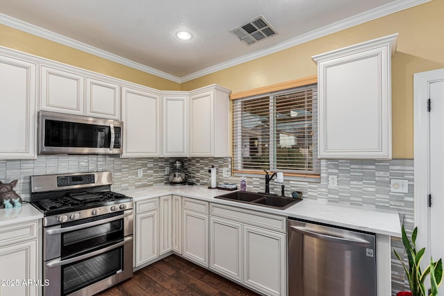 kitchen featuring sink, tasteful backsplash, appliances with stainless steel finishes, white cabinets, and ornamental molding