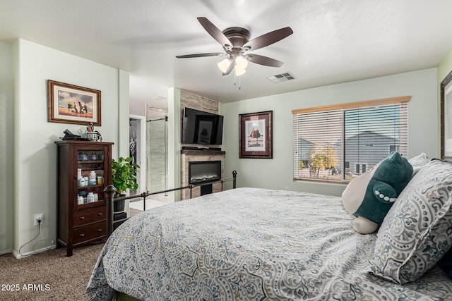 bedroom featuring a fireplace, light colored carpet, and ceiling fan