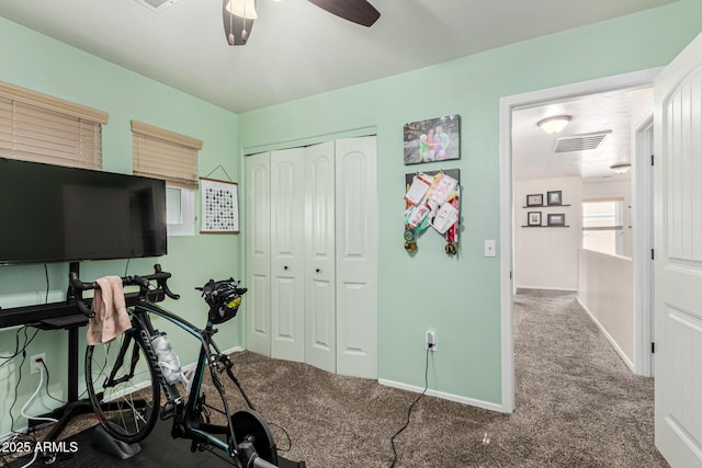 exercise room with ceiling fan and carpet floors