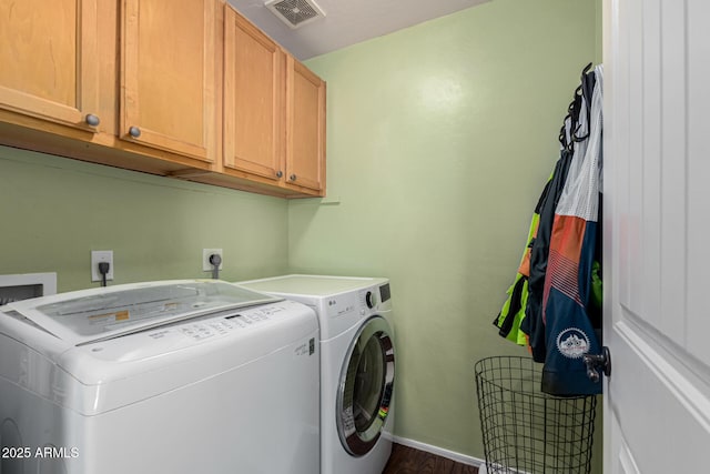 laundry area with cabinets, dark hardwood / wood-style flooring, and washer and clothes dryer