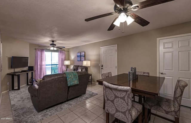 living room with ceiling fan, light tile floors, and a textured ceiling