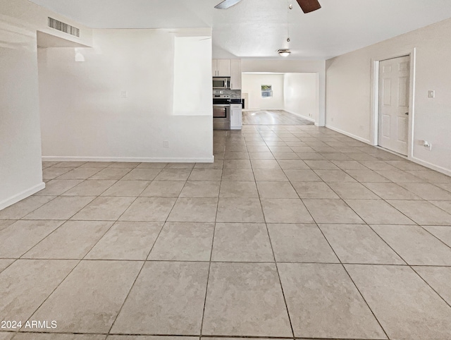 unfurnished living room featuring ceiling fan and light tile patterned flooring