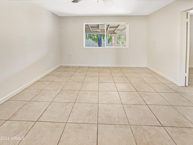 empty room with ceiling fan and light tile patterned flooring