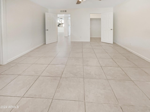 tiled empty room featuring ceiling fan