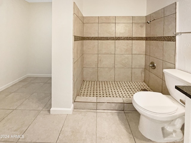 bathroom featuring tile patterned floors, toilet, and tiled shower