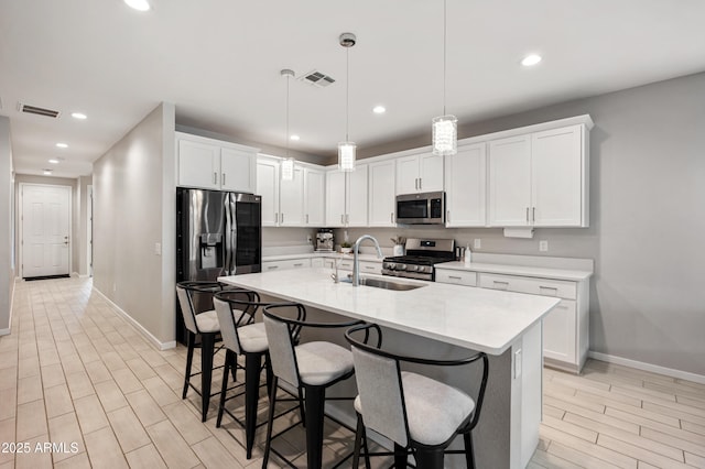 17968 W Hilton Ave, Goodyear, AZ 85338 - kitchen featuring stainless steel appliances, a sink, baseboards, light countertops, and a kitchen bar