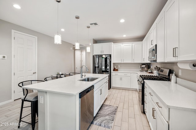 17968 W Hilton Ave, Goodyear, AZ 85338 - kitchen featuring stainless steel appliances, a sink, wood tiled floors, a breakfast bar, and recessed lighting