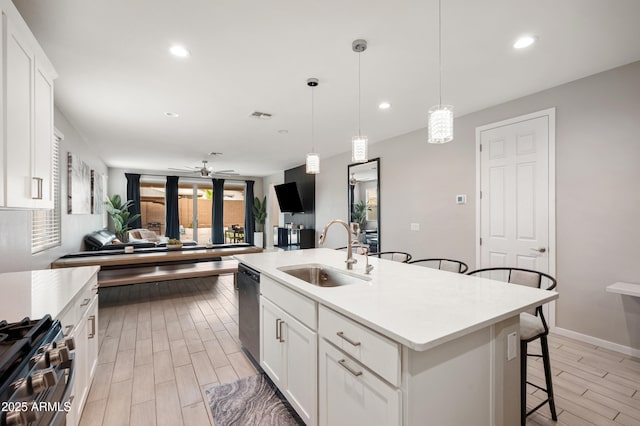 17968 W Hilton Ave, Goodyear, AZ 85338 - kitchen with a sink, appliances with stainless steel finishes, a breakfast bar area, light wood-type flooring, and light countertops