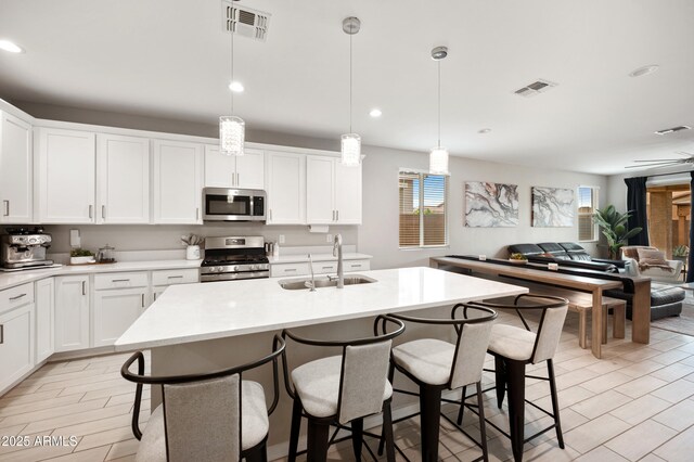 17968 W Hilton Ave, Goodyear, AZ 85338 - kitchen featuring appliances with stainless steel finishes, a sink, a breakfast bar area, open floor plan, and light countertops