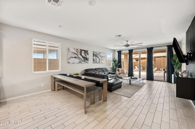 17968 W Hilton Ave, Goodyear, AZ 85338 - living room featuring baseboards, a ceiling fan, and light wood-style flooring