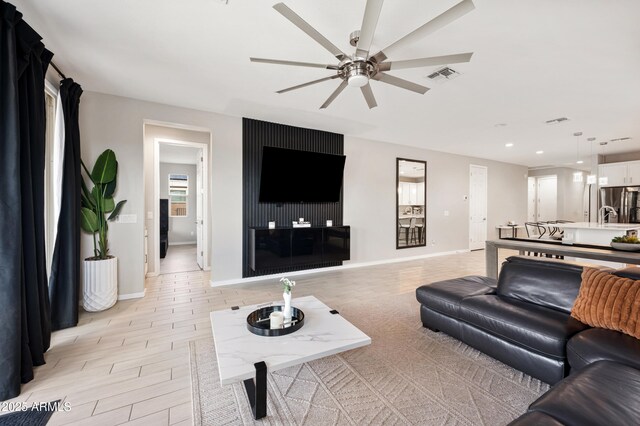 17968 W Hilton Ave, Goodyear, AZ 85338 - living room with ceiling fan, baseboards, recessed lighting, and light wood-style floors