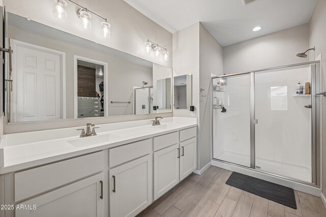 17968 W Hilton Ave, Goodyear, AZ 85338 - full bathroom featuring a shower stall, double vanity, and wood finished floors