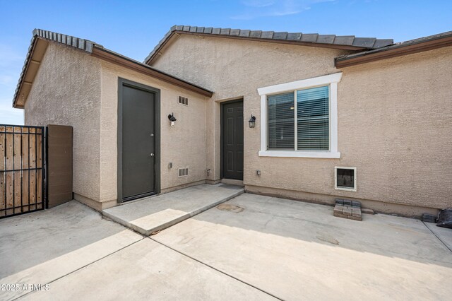 17968 W Hilton Ave, Goodyear, AZ 85338 - doorway to property with a patio, stucco siding, and a gate