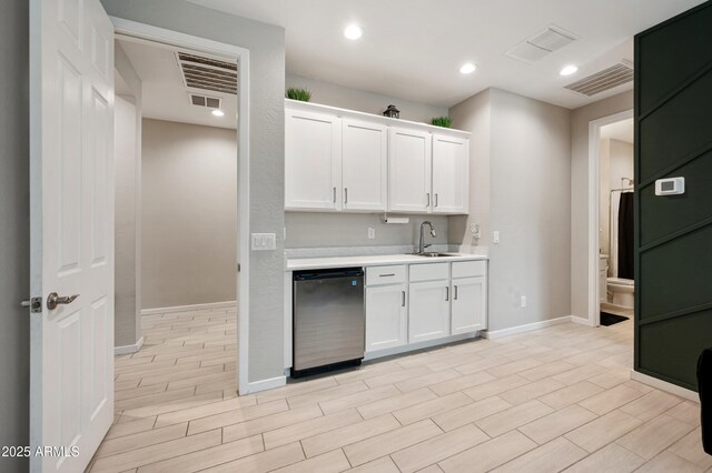 17968 W Hilton Ave, Goodyear, AZ 85338 - kitchen featuring stainless steel dishwasher, light countertops, a sink, white cabinetry, and baseboards