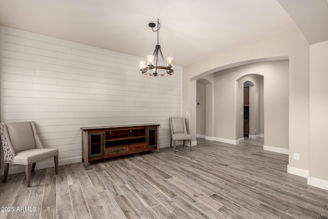 unfurnished room featuring hardwood / wood-style flooring and an inviting chandelier