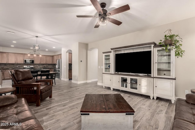 living room with ceiling fan and light hardwood / wood-style flooring