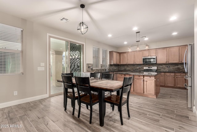 dining room with sink and light hardwood / wood-style flooring