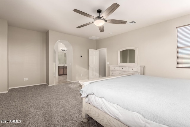 carpeted bedroom with ceiling fan and ensuite bath