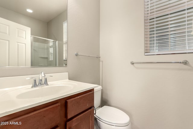 bathroom featuring vanity, toilet, and a shower with shower door