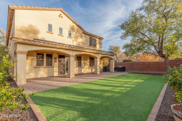 back of property featuring a patio and a yard