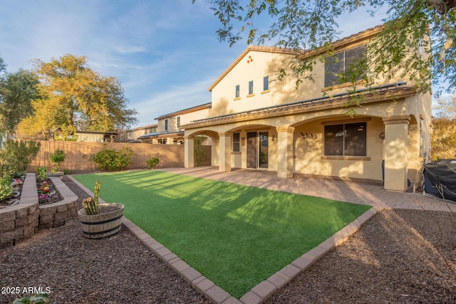 back of property with a yard and a patio area