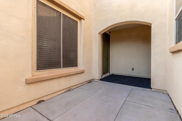 view of exterior entry with a patio