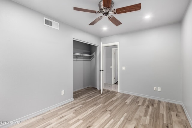 unfurnished bedroom featuring a closet, visible vents, a ceiling fan, wood finished floors, and baseboards