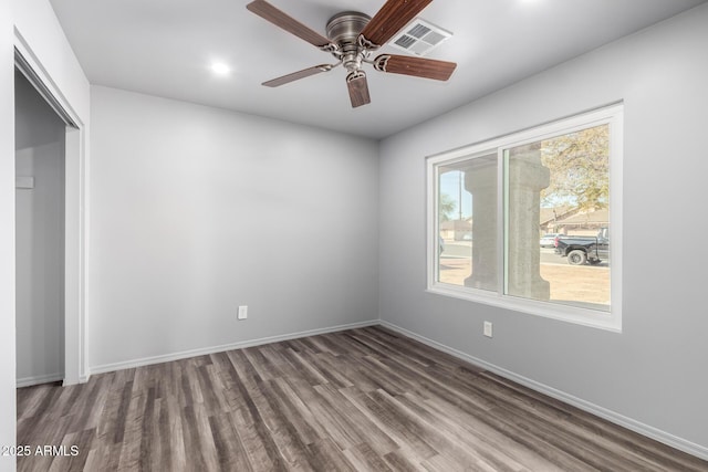 spare room with a ceiling fan, baseboards, visible vents, and wood finished floors