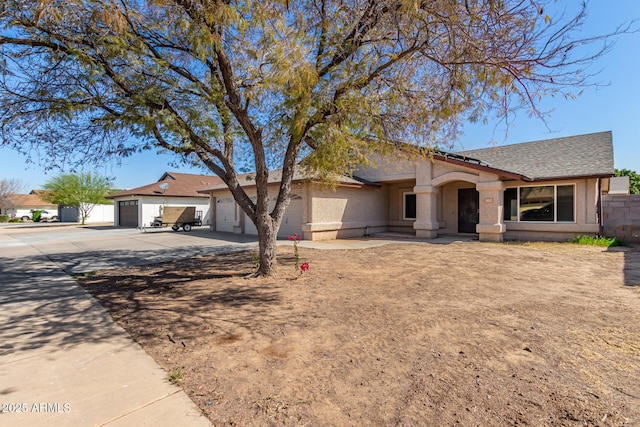 ranch-style house with a garage, concrete driveway, and a shingled roof