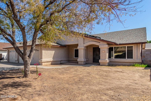 view of front of home featuring a garage, concrete driveway, and roof with shingles