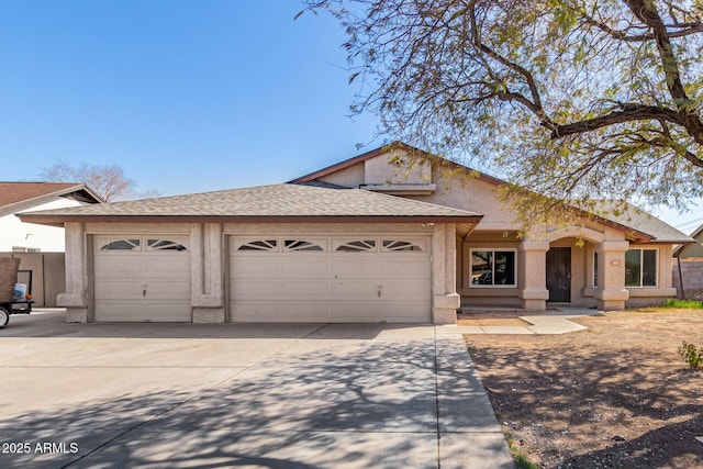 view of front of property with an attached garage, driveway, and a shingled roof