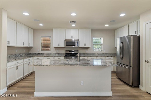 2868 E Binner Dr, Chandler, AZ 85225 - kitchen featuring stainless steel appliances, white cabinetry, a sink, wood finished floors, and recessed lighting