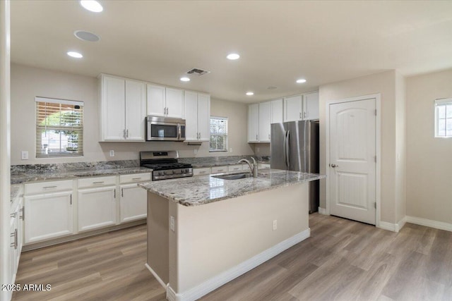 2868 E Binner Dr, Chandler, AZ 85225 - kitchen with stainless steel appliances, light wood-style flooring, white cabinets, and recessed lighting