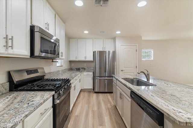 2868 E Binner Dr, Chandler, AZ 85225 - kitchen with stainless steel appliances, a sink, light wood-type flooring, white cabinetry, and recessed lighting