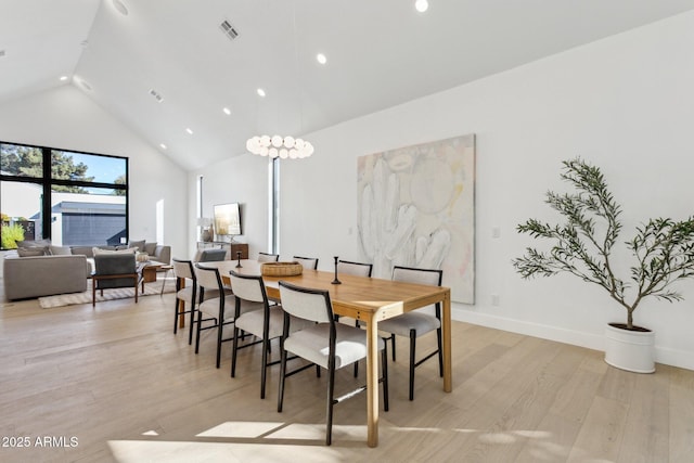 dining space featuring light hardwood / wood-style flooring and high vaulted ceiling