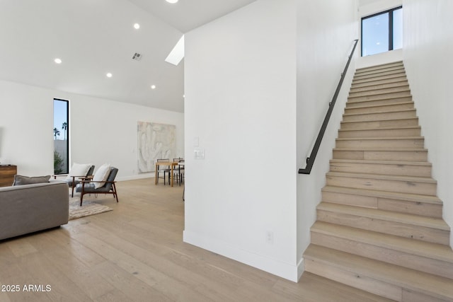 stairs featuring hardwood / wood-style floors and a towering ceiling