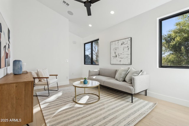 living room featuring vaulted ceiling, ceiling fan, and light hardwood / wood-style flooring