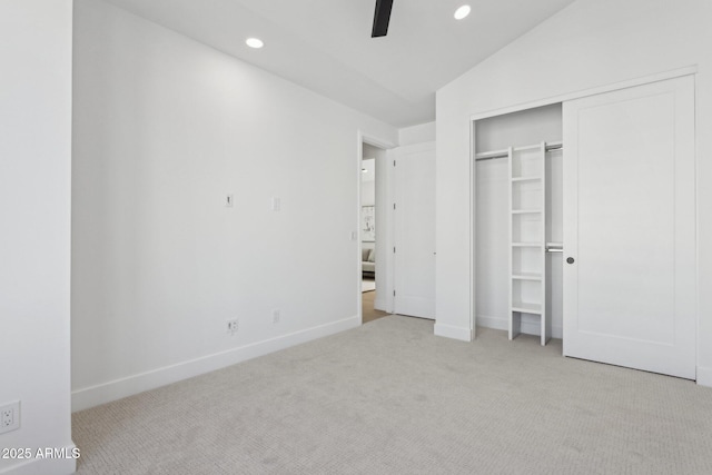 unfurnished bedroom featuring lofted ceiling, light carpet, ceiling fan, and a closet