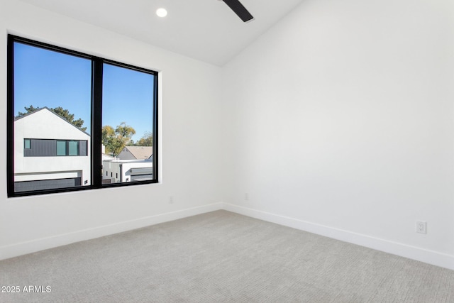 carpeted empty room featuring vaulted ceiling and ceiling fan