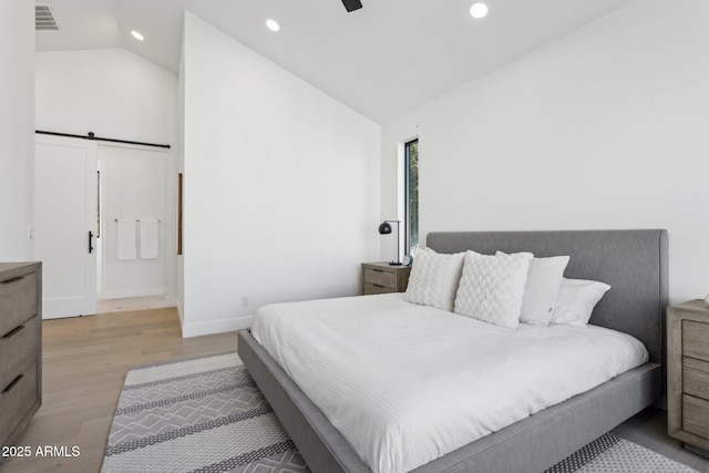 bedroom featuring ceiling fan, lofted ceiling, and light hardwood / wood-style flooring